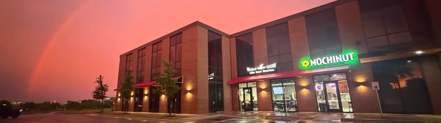 Mochinut Cedar Park storefront under a pink evening sky with a rainbow